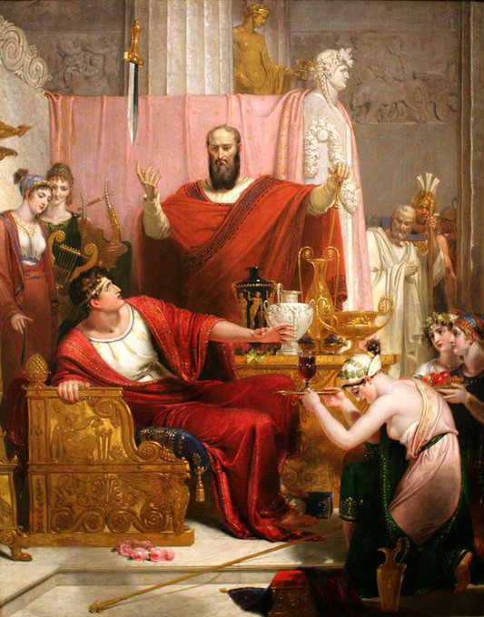 A classical painting depicting a lavish ancient Roman scene, featuring a bearded man in a red toga standing with arms raised before a reclining figure on an ornate golden couch, surrounded by elaborately dressed attendants, musicians with a harp and lyre, a golden statue, and richly decorated vessels and goblets.