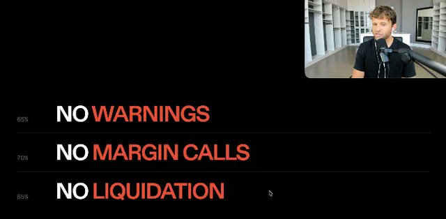 A man presents a slide with bold white-and-red text reading "65% NO WARNINGS," "70% NO MARGIN CALLS," and "85% NO LIQUIDATION," visually supporting Strike's new "volatility-proof" Bitcoin-backed loans that aim to eliminate margin calls and forced liquidations for borrowers maintaining 14% interest payments.