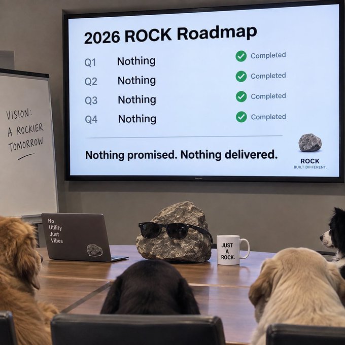 A humorous presentation slide titled '2026 ROCK Roadmap' displayed in a meeting room, listing all four quarters as 'Nothing' and 'Completed' with the tagline 'Nothing promised. Nothing delivered.' Dogs are seated in the foreground watching, and a rock wearing sunglasses sits on the table with a 'JUST ROCK' mug.