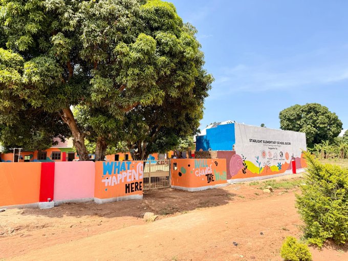 Exterior of Starlight Elementary School in Balama with a colorful gate reading 'WHAT HAPPENS HERE' and 'YOU CAN CHANGE THE',