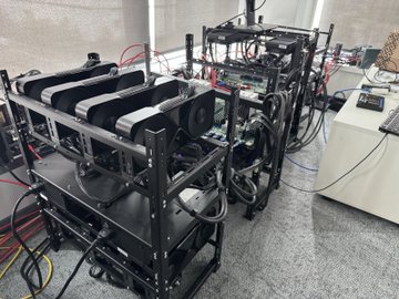 This image shows a large setup of GPUs, or "friends in high places," likely for cryptocurrency mining or AI computation. The elaborate rack system and multiple graphics cards suggest a significant investment in high-performance computing.