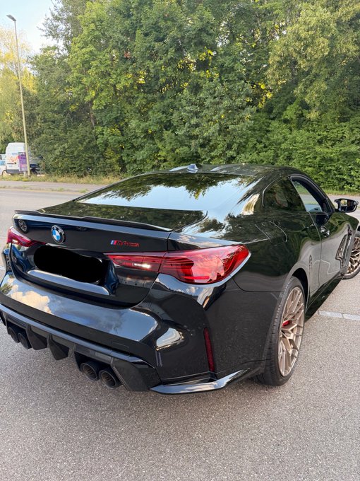A sleek black BMW M8 Competition coupe is parked outdoors, with its distinctive quad exhaust tips and M badge visible on the rear. The post humorously thanks Solana, suggesting the car's purchase was funded by cryptocurrency gains.