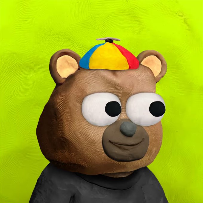 A 3D rendered brown bear character with large white eyes wearing a colorful propeller beanie cap and a black shirt against a green background.