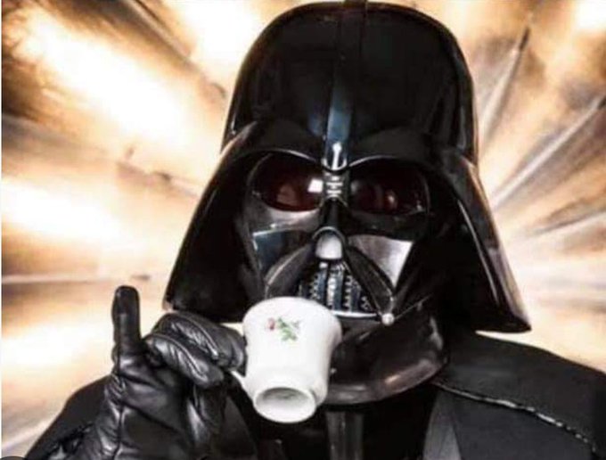 A person dressed as Darth Vader from Star Wars is holding and sipping from a delicate white floral teacup, creating a humorous contrast between the menacing Sith Lord and dainty tea culture. The image relates to the post "GM beaches." (likely meaning "GM beaches it" — a colloquial expression for messing up or failing) by visually suggesting that something which should be intimidating or powerful (like a Sith Lord) has instead been portrayed in a soft, harmless, or comically ineffective way, much like a major corporation fumbling a product launch.