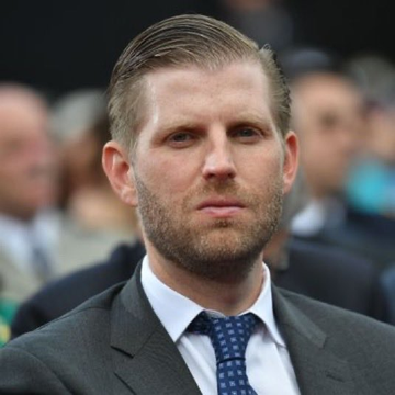 The image shows Eric Trump, son of President Donald Trump, wearing a dark suit, white shirt, and blue polka-dot tie with a serious expression. The post attributes a bullish statement to him, claiming gold profits will soon rotate into Bitcoin—aligning with the serious, professional appearance of the man pictured, though no text or identifying labels appear directly in the image itself.