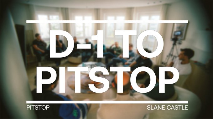 A video thumbnail or graphic with bold white text reading 'D-1 TO PITSTOP' and 'SLANE CASTLE' overlaid on a blurred image of a group of people gathered in a room.