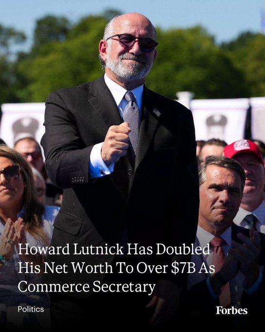The image shows a man in a dark suit, white shirt, and gray tie, clapping with a determined expression, set against a backdrop of trees and a banner with images of Ronald Reagan, alongside two other men in suits and red caps. The Forbes headline reads, "Howard Lutnick Has Doubled His Net Worth To Over $7B As Commerce Secretary," aligning with the post about Lutnick's wealth surge to $7.3 billion during his time in Trump's Cabinet, primarily through his stake in Cantor and indirect holdings in Tether.