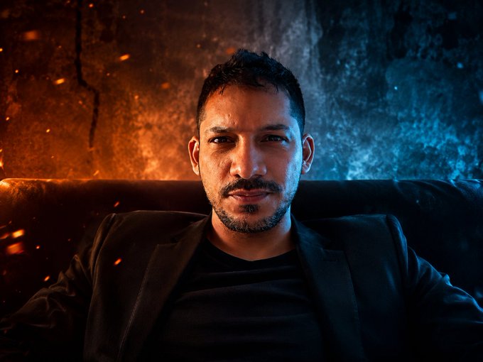 A man, Jérémie Cohen, is pictured with a dramatic orange and blue background, representing his personal brand GRM. The image reflects his statement about identity in the crypto world, where his brand name GRM is easily discoverable.