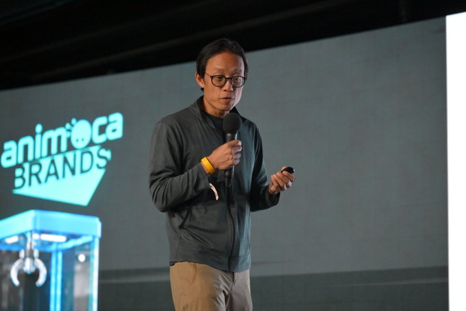 Yat Siu, executive chairman and co-founder of Animoca Brands, stands on stage holding a microphone and clicker while presenting in front of the Animoca Brands logo, illustrating his vision for the company's focus on agentic AI and economic sovereignty in the next era of the internet.