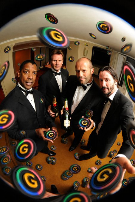Four men in black tuxedos pose together holding champagne bottles, with floating Google 'G' logos surrounding them in a fisheye-lens perspective.