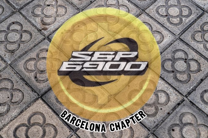 The image features a circular logo with a yellow background, displaying "SPX 6900" in bold stylized text, with "BARCELONA CHAPTER" written along the bottom curve, all overlaid on a decorative tiled pavement pattern. The logo visually represents the official launch of the SPX6900 community's Barcelona Chapter, reinforcing the post's announcement about promoting SPX6900 locally and supporting the broader Spanish-speaking community.
