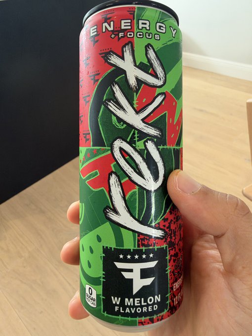 A hand holds a "FOKR ENERGY + FOCUS" can in W MELON FLAVORED with 0 sugar and 100 calories, perfectly matching the "gm" (good morning) post as a morning pick-me-up beverage.