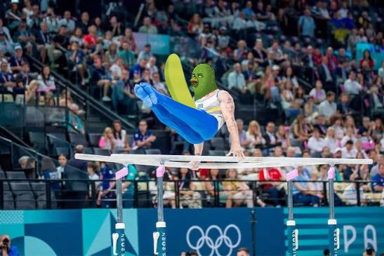 A photoshopped image shows a gymnast with a pickle head and blue inflatable dolphin costume performing on the pommel horse at the Paris 2024 Olympics.