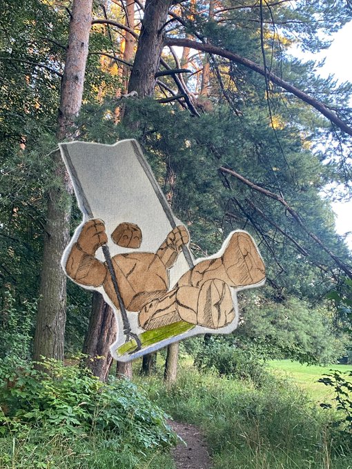 An illustration of a muscular stone golem character lifting a large slab, photoshopped onto a background photo of a forest path.