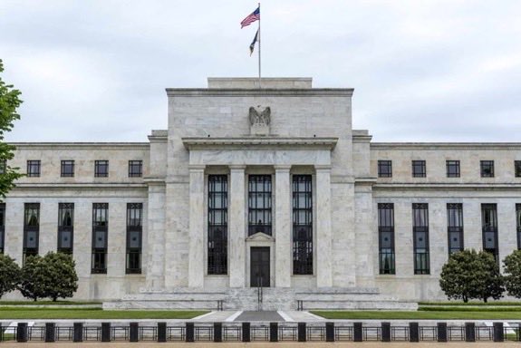 The image shows the Federal Reserve building in Washington, D.C., an imposing neoclassical stone structure topped with an American flag, which visually anchors the post's claim of an official Fed report on crypto adoption rates. The accompanying text cites the Federal Reserve as confirming that 10% of Americans own crypto, framing this data point as evidence of accelerating mainstream adoption.