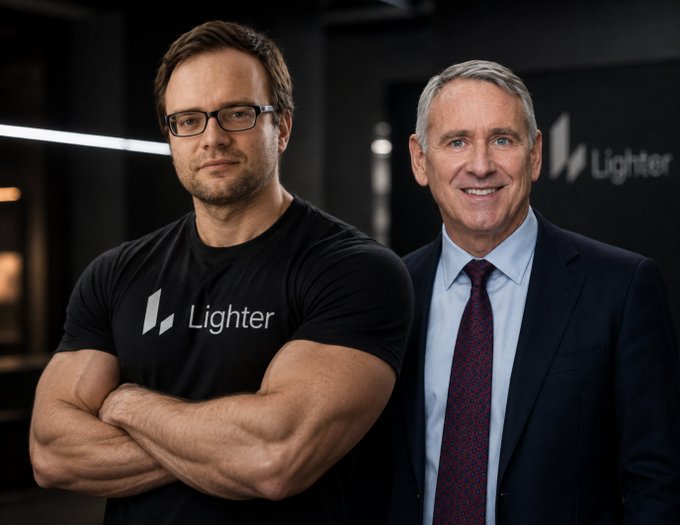 Two men pose together, with the younger man on the left wearing a black t-shirt featuring the 'Lighter' logo, and the older man on the right in a suit with a maroon tie.