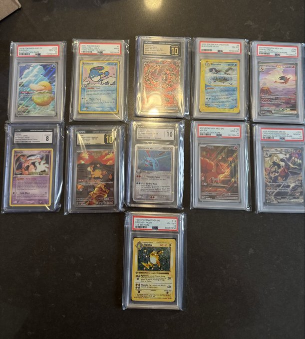 The image features a collection of Pokemon cards neatly arranged on a table, with each card individually protected by plastic sleeves. The cards are organized in two rows, showcasing a variety of Pokemon characters from different series. The post about the Pokemon cards has been shared, and it seems that someone is excitedly discussing their collection or sharing their interest in these cards.
