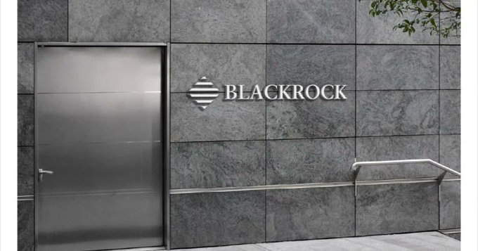 The exterior of a BlackRock office building with the company's logo and name displayed on a dark stone wall next to a metal door.