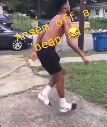 The image shows a man wearing black shorts, white socks, and shoes while standing on a sidewalk with his arms outstretched as if he's jumping or running. The caption of the image reads "Ansem off a bean". This phrase is likely a reference to the popular meme about anemometers being used as a prop in a dance routine.

The background features several cars parked along the street, and there are also two trash cans visible nearby.