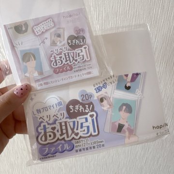 A hand holds up two packages of "hopika" photo/file sleeve refills (20-page size, 56×127mm, 2-pack, with "Sukepu de" printing), shown against a white background, fitting the post's theme of using these clear protective sleeves to store and trade Pokémon-style cards like a file-ready collection.