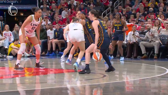 A WNBA basketball game in progress showing Indiana Fever players in navy uniforms playing against the Chicago Sky, with the arena scoreboard visible in the background.