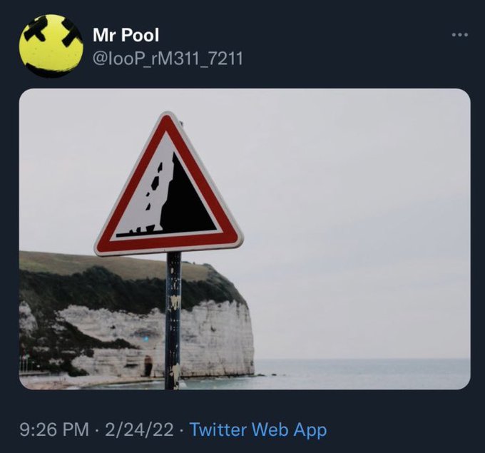 A tweet from user "Mr Pool" (@looP_rM311_7211) posted at 9:26 PM on 2/24/22 features a "falling rocks" warning sign placed near white cliffs by the sea, humorously serving as a visual metaphor for the accompanying caution about XRP price declines.