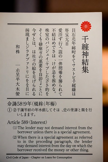 A placard displays Article 589 of Japan's Civil Code (Chapter on Loans for Consumption), titled "千種神結集" with a red chrysanthemum emblem, explaining that lenders may not demand interest from borrowers without a special agreement, which the post references as a key legal tool against yen carry trades.
