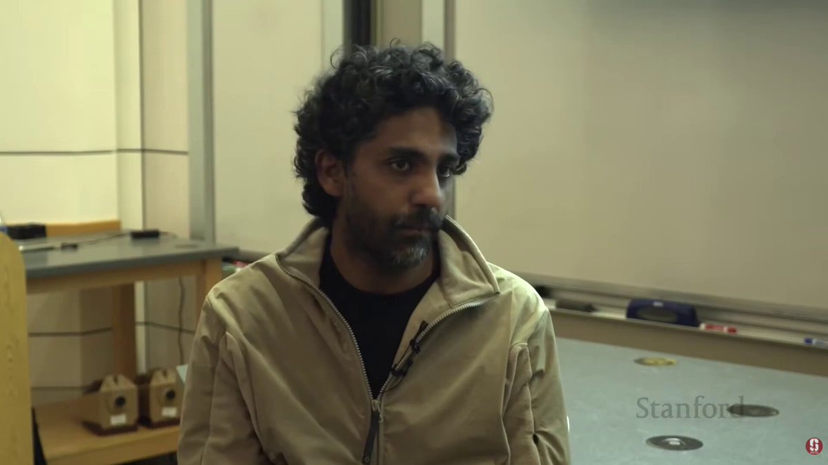 The image features a man with curly hair wearing a tan jacket, sitting in front of a whiteboard or board. The background appears to be a classroom setting, which adds context to the scene. The caption "Reminds me of the dynamics around bitcoin mining ASICs in 2021" suggests that there might be an interesting parallel between the man's appearance and the dynamics surrounding Bitcoin mining in the year 2081. This could imply a connection between the man's curly hair and the unique characteristics of Bitcoin mining technology, or it may simply be a coincidence with no deeper meaning.