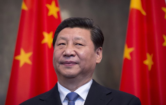 Xi Jinping stands in front of Chinese flags as China's PBOC injects $52 billion into its banking system, prompting market questions about increased risk appetite.