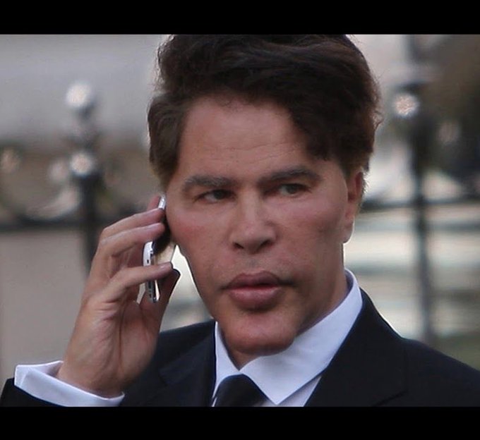 The image depicts a man dressed in a suit talking on his cell phone. His facial expression conveys seriousness, as he is engaged in an important conversation or discussing something of significant importance. The text in the image reads "Just In: BlackRock just deposited $172M worth of Bitcoin and Ethereum to Coinbase Prime". This detail suggests that the man's focus on the cellphone call may have a connection with cryptocurrency trading or investment, possibly related to the recent news about the transaction happening through Coinbase.