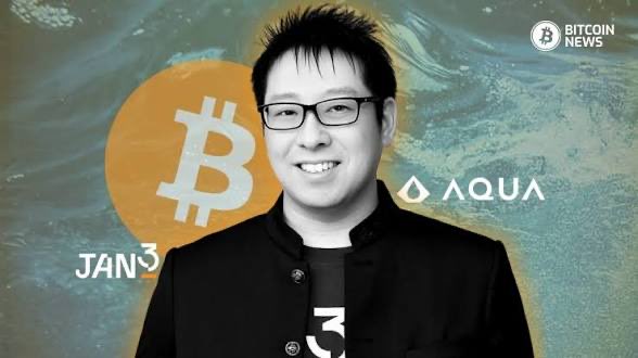 A Bitcoin News graphic featuring a smiling man in glasses and a black jacket, with Bitcoin and AQUA logos, and the date 'JAN 3' displayed on a stylized water background.