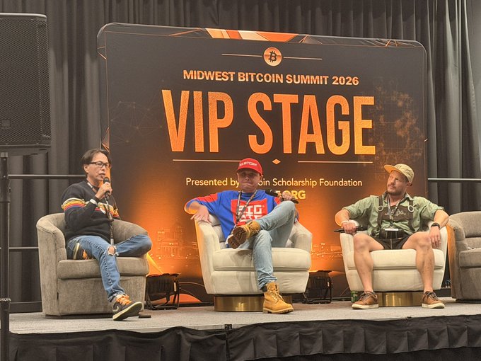 Three men seated in chairs on stage at the 'MIDWEST BITCOIN SUMMIT 2026 VIP STAGE,' presented by the Bitcoin Scholarship Foundation, with one man holding a microphone.
