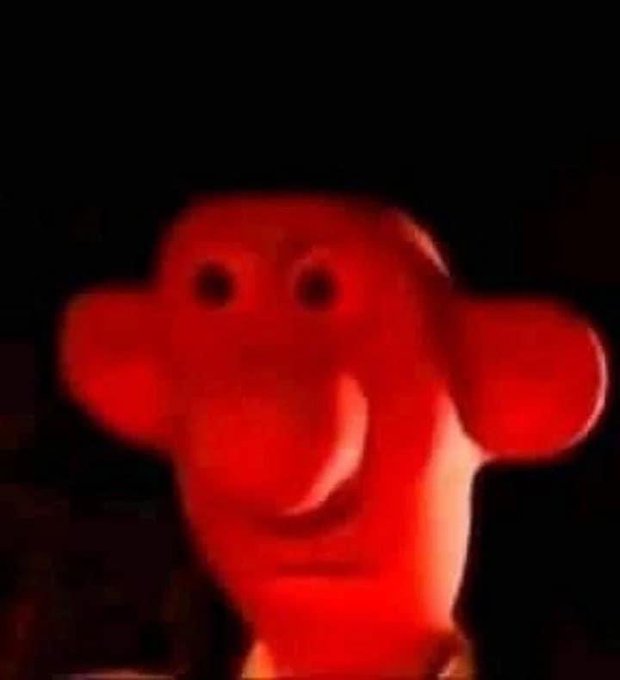 The image features a red plastic toy, possibly a stuffed animal or a doll, with a face that looks like a cartoon character. The toy appears to be made of plastic and has a round head and an open mouth. It seems to be posed for a photo against a dark background, which makes it stand out prominently in the image. The caption below the image reads "$GME Full release: investor.gamestop.com/news-releases/ ...". This suggests that the toy is part of a larger collection or series related to the gaming industry and could be a product or promotional item for a gaming company, event, or merchandise line.