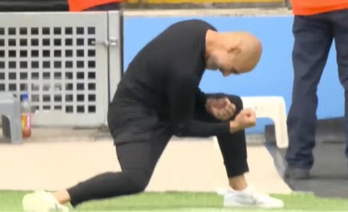 A bald man dressed in black athletic wear kneels on the sideline of a sports field, leaning forward with his fists clenched in what appears to be an emotional or celebratory gesture, likely a coach or player reacting to a moment in a game. The image connects to the post's theme of celebration and gratitude, as the man's intense, triumphant pose mirrors the excitement of achieving a significant gain ("10x") in the market.