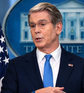 Treasury Secretary Scott Bessent speaks at a White House press briefing podium, addressing reporters. The image accompanies a post in which Bessent calls on the Senate to pass the CLARITY Act.