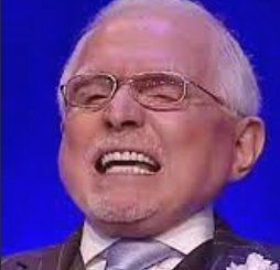Warren Buffett laughing broadly while wearing glasses and a suit.