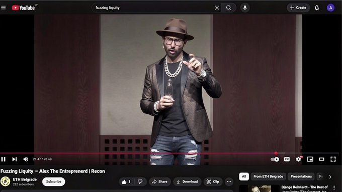 A YouTube video titled 'Fuzzing Liquidity' by ETH Belgrade shows a man wearing a hat, glasses, and blazer giving a presentation about 'Alex The Entrepreneur | Recon'.