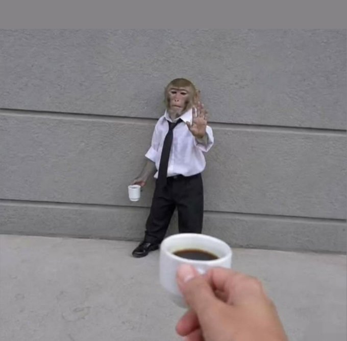 A monkey in a white shirt and tie raises its hand and holds a small cup, while a person's hand offers another cup of coffee in the foreground, symbolizing a casual "GM" (good morning) coffee break to kick off the day of grinding.
