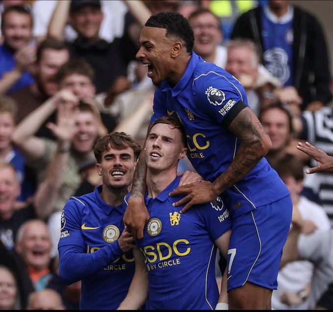 Chelsea players celebrate enthusiastically on the pitch, with one jumping onto his teammate's back in front of cheering fans. The players' blue jerseys prominently display "USDC" and "BY CIRCLE" sponsor logos, aligning with the post about the "USDC Era" at Chelsea FC.