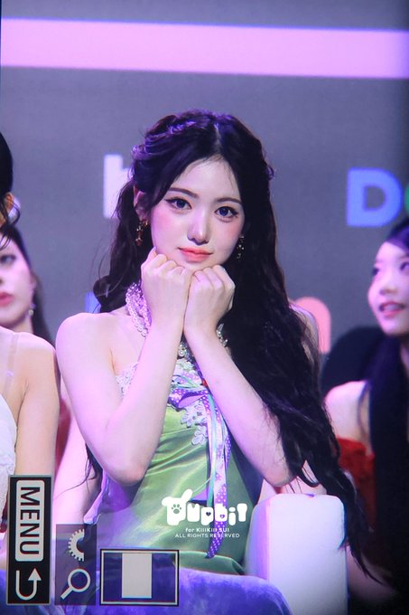 A young woman with long dark hair in a green floral halter dress at what appears to be an awards ceremony, with TV menu graphics overlaid on the image.