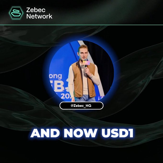 A man with blonde hair wearing a tan vest speaks into a microphone on stage, framed within a circular graphic displaying the Zebec Network logo and the handle "@Zebec_HQ." Bold text at the bottom reads "AND NOW USD1," aligning with the post announcing that USD1 is now live across the Zebec ecosystem for payroll, payments, and yield solutions via the SuperApp and ZebecCards.