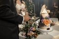 A person in a dark suit stands at a beautifully decorated table featuring an elegant floral centerpiece, candles, and festive table settings.