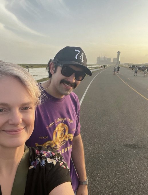 The image shows @dogeofficialceo in a purple Metro-Goldwyn-Mayer shirt and a hat with "74" on it, posing for a selfie with another person at Starbase. The post invites viewers to join them for a fun conversation.