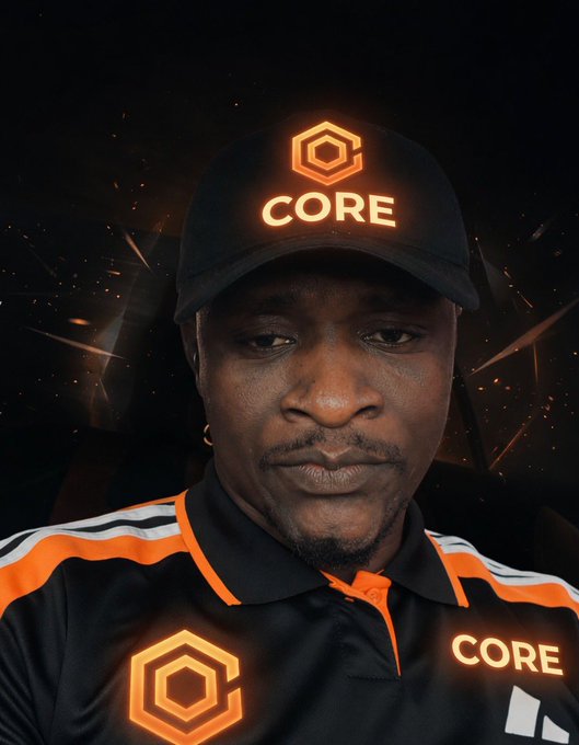 A man wearing a black cap and polo shirt branded with 'CORE' logo and text, set against a dark background with glowing orange particles.