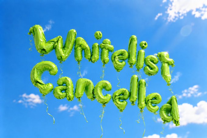 The image shows green foil balloons spelling out "Mini Gengar" floating in a bright blue sky, though the text appears slightly misspelled as "Mini Gengalla" in the balloon lettering. The cheerful, playful image of celebratory balloons contrasts with the post's message about canceling a whitelist due to botted entries and fraudulent addresses.