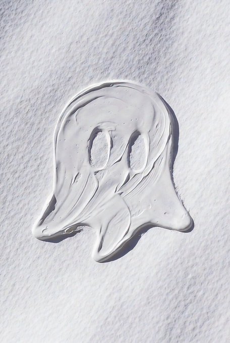 The image features a white ghost-like shape drawn or painted onto a sheet of paper. The ghost appears to be made out of frosting or icing, giving it a spooky appearance. The background of the image is a plain white sheet of paper with no other objects or distractions present. The focus of the image seems to be on the ghost and its unique design rather than any additional elements in the scene.
