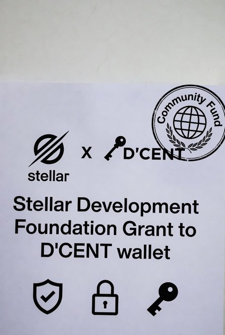 The image features a poster or flyer promoting a new wallet called D'CENT, which has been selected for the Stellar Community Fund. The poster highlights that this wallet is backed by the Stellar ecosystem and was chosen as one of the winning projects from the 2020 Stellar Community Foundation Grant competition. It also mentions that the wallet is built on the $XLM network, indicating its connection to Bitcoin Core technology.