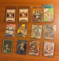 A small collection of approximately eleven illustrated trading cards or game cards scattered on a wooden surface, featuring various character portraits and symbols.