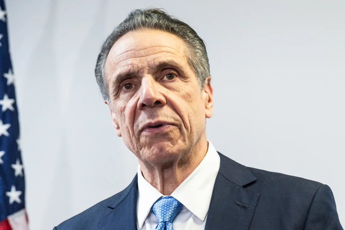 The image features a man dressed in a suit and tie, standing against a white background with an American flag behind him. The man appears to be speaking or giving a speech, as indicated by his facial expression. In the background, there are two prominent stars on the flag, which is located at the top left corner of the image.

The caption for this image reads: "NEW: ICE, the owner of the New York Stock Exchange, and crypto exchange OKX are launching a 50-50 joint venture focused on digital financial products, including tokenized securities".