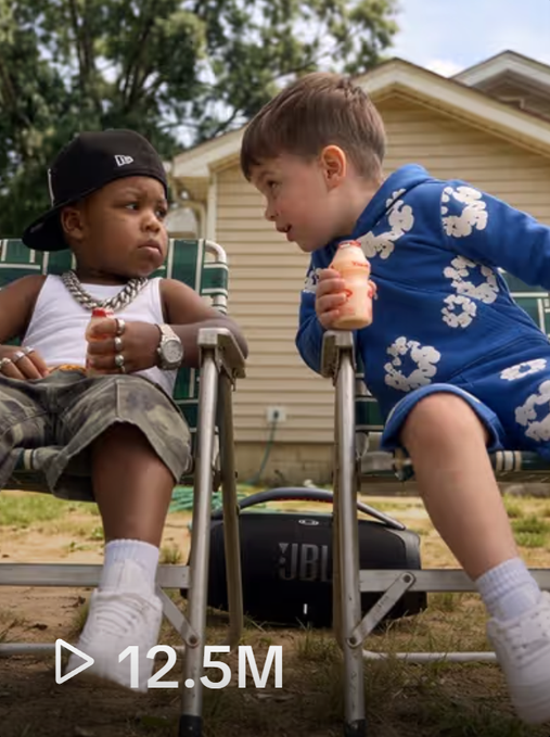 A viral social media thumbnail showing two young children sitting in lawn chairs with snacks and a JBL speaker between them, displaying '12.5M' views.